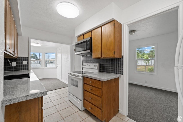 37 N Lakeview Dr, Clearfield, UT 84015 - kitchen with stainless steel microwave, white electric stove, light colored carpet, and a textured ceiling