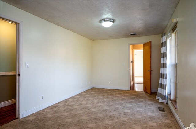 4180 Liberty Ave, South Ogden, UT 84403 - spare room featuring light carpet, baseboards, visible vents, and a textured ceiling