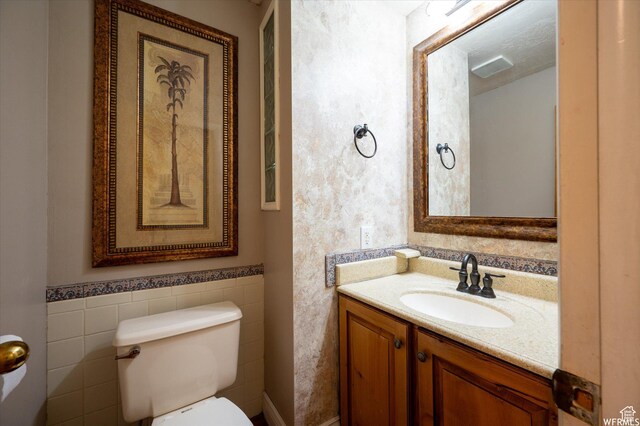 4180 Liberty Ave, South Ogden, UT 84403 - bathroom featuring tile walls, toilet, vanity, and wainscoting