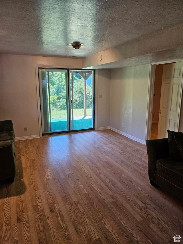 4180 Liberty Ave, South Ogden, UT 84403 - unfurnished living room featuring baseboards, wood finished floors, and a textured ceiling