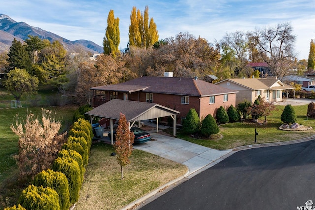 4180 Liberty Ave, South Ogden, UT 84403 - view of front of house with concrete driveway, a mountain view, and a front lawn