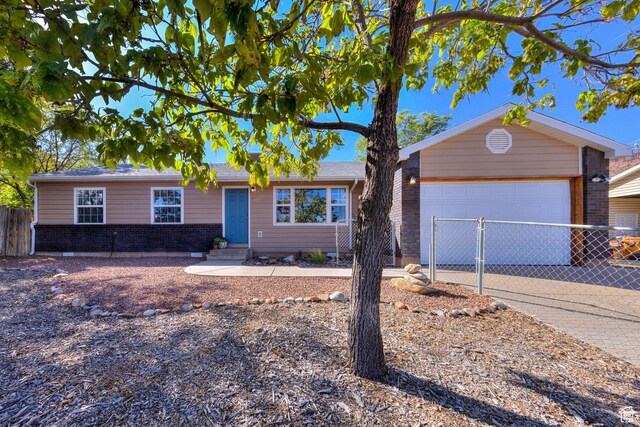 1122 E Holyoak Ln, Moab, UT 84532 - ranch-style house with a garage, fence, brick siding, entry steps, and driveway