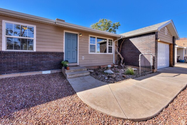 1122 E Holyoak Ln, Moab, UT 84532 - ranch-style home with an attached garage, driveway, and brick siding