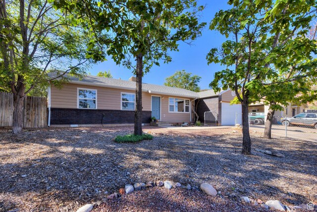 1122 E Holyoak Ln, Moab, UT 84532 - single story home with brick siding, an attached garage, and fence