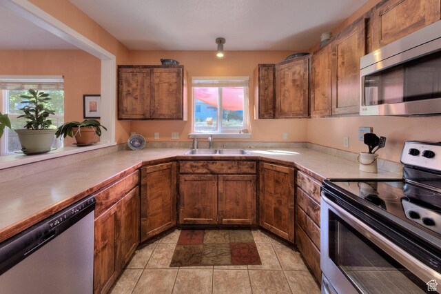 1122 E Holyoak Ln, Moab, UT 84532 - kitchen with light countertops, appliances with stainless steel finishes, brown cabinetry, and a sink
