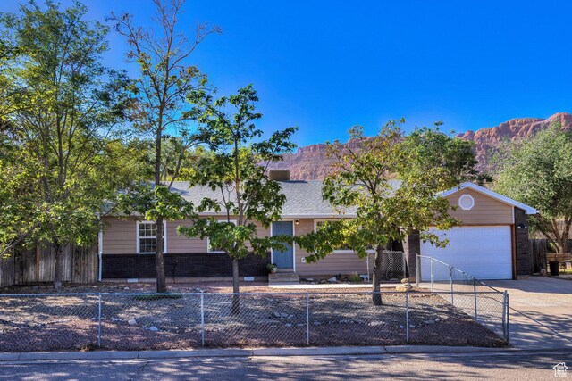 1122 E Holyoak Ln, Moab, UT 84532 - view of front of property with a fenced front yard, a mountain view, and driveway