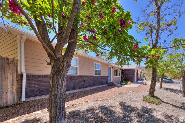 1122 E Holyoak Ln, Moab, UT 84532 - view of property exterior with brick siding, fence, and entry steps