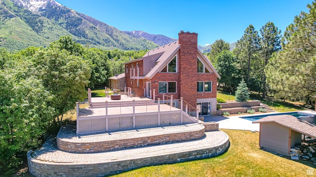410 S Woodland Hills Dr, Woodland Hills, UT 84653 - back of property featuring a lawn, a chimney, a patio, and a mountain view