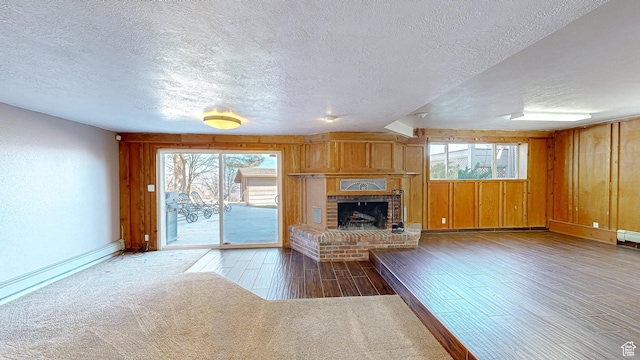 410 S Woodland Hills Dr, Woodland Hills, UT 84653 - unfurnished living room with a textured ceiling, carpet floors, wooden walls, a brick fireplace, and wood finished floors
