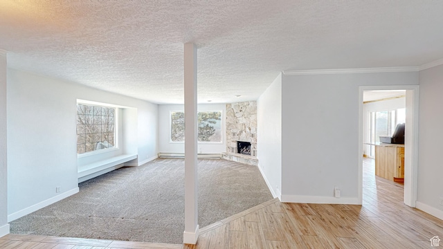 410 S Woodland Hills Dr, Woodland Hills, UT 84653 - unfurnished living room featuring carpet flooring, baseboards, a textured ceiling, a fireplace, and wood finished floors