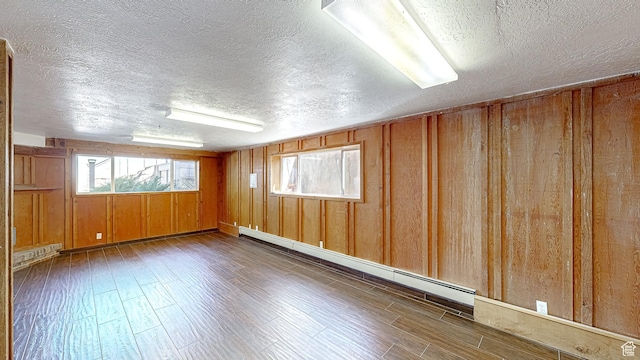 410 S Woodland Hills Dr, Woodland Hills, UT 84653 - unfurnished room featuring a baseboard radiator, wooden walls, a baseboard heating unit, and wood finished floors