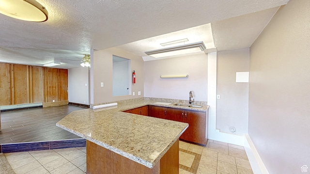 410 S Woodland Hills Dr, Woodland Hills, UT 84653 - kitchen with a textured ceiling, a peninsula, a ceiling fan, a sink, and a baseboard heating unit