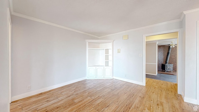410 S Woodland Hills Dr, Woodland Hills, UT 84653 - empty room featuring baseboards, light wood-type flooring, crown molding, and a wood stove
