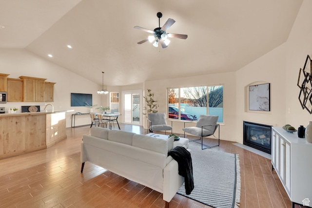 1052 S 350 E, Payson, UT 84651 - living area with light wood finished floors, a ceiling fan, a chandelier, a fireplace with flush hearth, and high vaulted ceiling