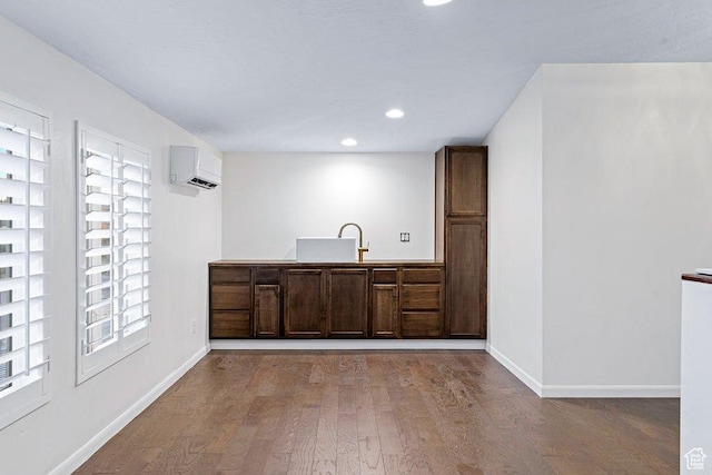 kitchen featuring recessed lighting, a wall mounted AC, baseboards, and wood finished floors