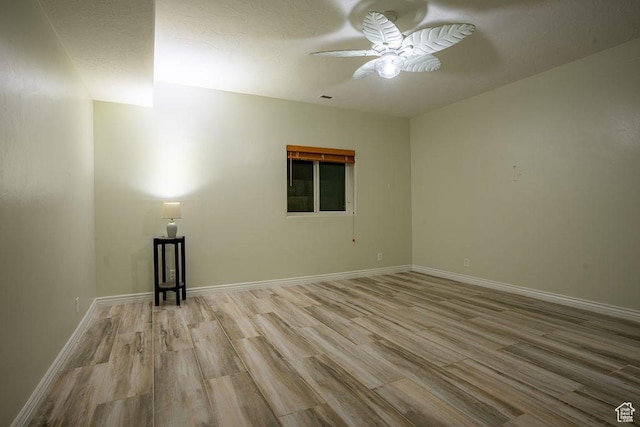 empty room with baseboards, ceiling fan, and wood finished floors