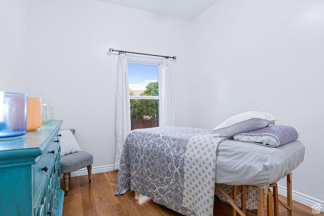 bedroom featuring baseboards and wood finished floors