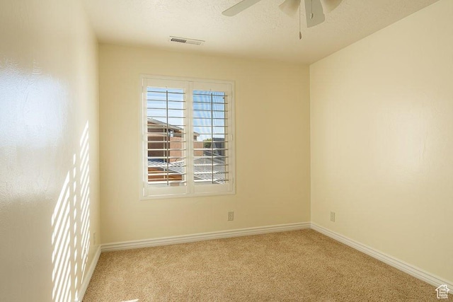 carpeted empty room featuring a ceiling fan, a textured ceiling, baseboards, and visible vents