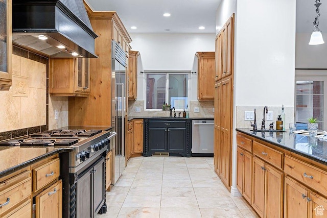 kitchen with stainless steel appliances, tasteful backsplash, a sink, and extractor fan
