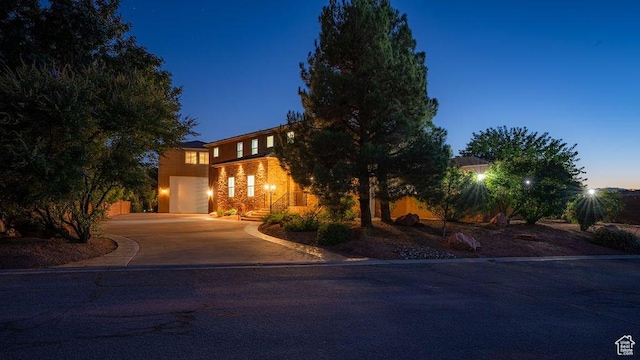 obstructed view of property with curved driveway and a garage