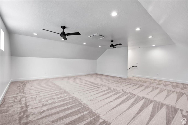 additional living space featuring carpet floors, vaulted ceiling, visible vents, and ceiling fan