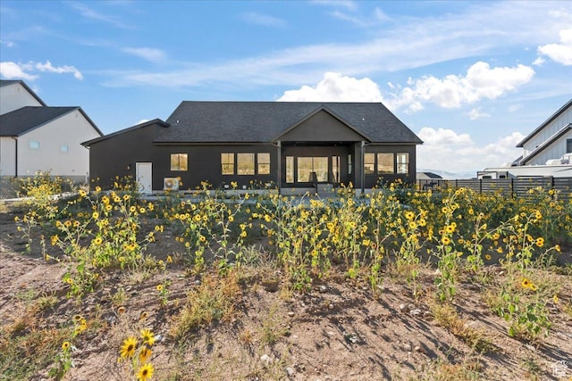 back of property with stucco siding and fence