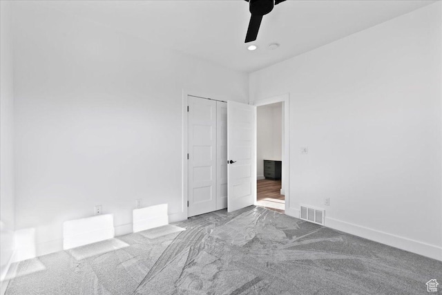 carpeted spare room with a ceiling fan, baseboards, and visible vents