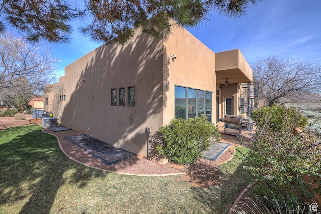 4985 W Boulder Vw, Hurricane, UT 84737 - view of side of property featuring stucco siding, stairway, a lawn, ceiling fan, and a patio area
