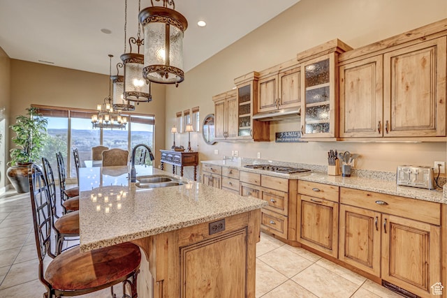 4985 W Boulder Vw, Hurricane, UT 84737 - kitchen featuring stainless steel gas cooktop, a sink, a kitchen bar, under cabinet range hood, and light tile patterned floors