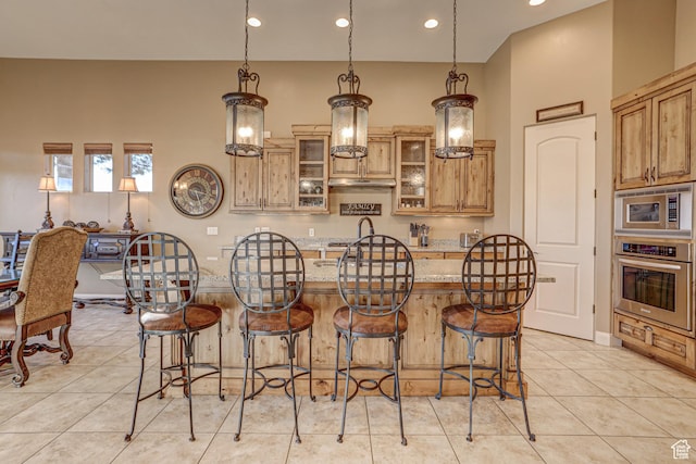 4985 W Boulder Vw, Hurricane, UT 84737 - kitchen with light stone countertops, a kitchen bar, stainless steel appliances, glass insert cabinets, and an island with sink