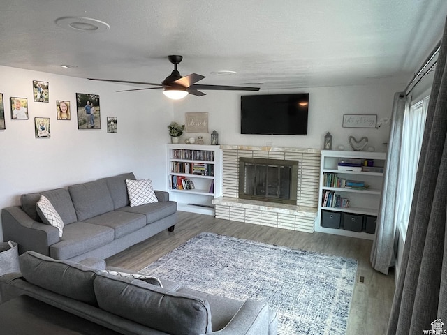 466 W 200 N, Logan, UT 84321 - living room with a textured ceiling, a brick fireplace, wood finished floors, and a ceiling fan