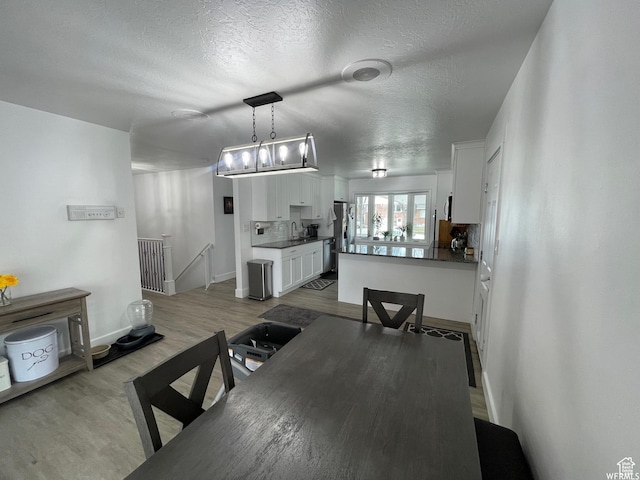466 W 200 N, Logan, UT 84321 - dining room featuring a textured ceiling, light wood-type flooring, and baseboards