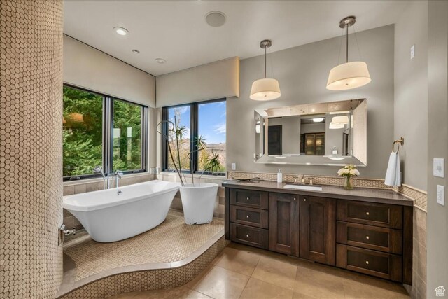 2196 W Long Sky Dr, St George, UT 84770 - full bathroom featuring vanity, wainscoting, a freestanding bath, tile walls, and tile patterned floors