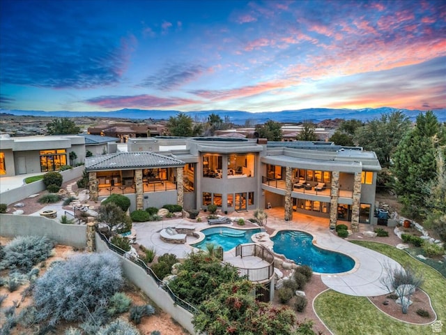 rear view of property with a patio area, a fenced backyard, a jacuzzi, and a balcony
