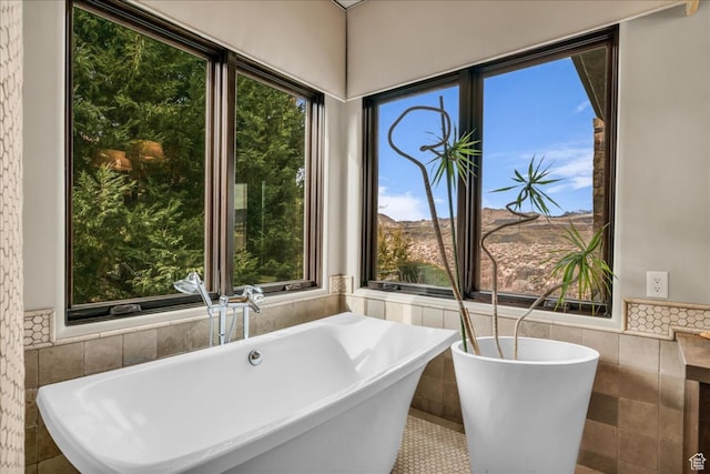 2196 W Long Sky Dr, St George, UT 84770 - bathroom featuring a wealth of natural light, wainscoting, tile walls, and a soaking tub