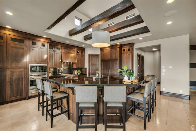 2196 W Long Sky Dr, St George, UT 84770 - kitchen featuring range hood, a breakfast bar, appliances with stainless steel finishes, dark countertops, and a spacious island