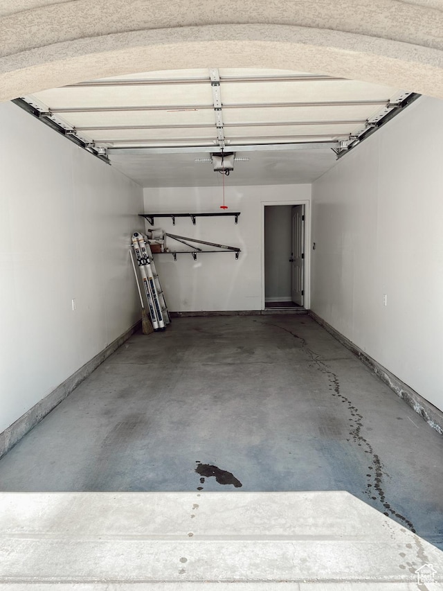 garage featuring a garage door opener and baseboards