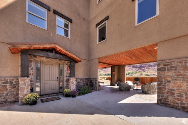 1261 N Main Rubicon Trl Unit M-14, Moab, UT 84532 - view of exterior entry with a patio, stucco siding, and stone siding