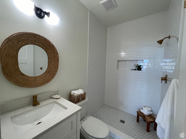 544 Lotus Dr, Fish Haven, ID 83287 - bathroom featuring vanity, toilet, tile patterned flooring, and a tile shower