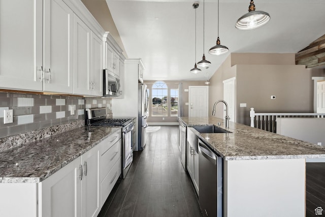 kitchen featuring a sink, a center island with sink, stainless steel appliances, white cabinets, and dark wood-style floors