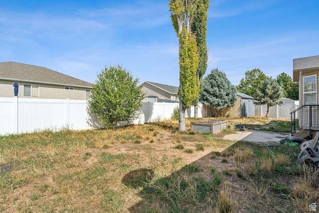 view of yard with a fenced backyard, an outdoor structure, and a vegetable garden