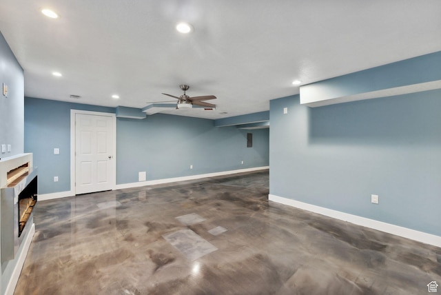 unfurnished living room with a ceiling fan, a fireplace, baseboards, concrete flooring, and recessed lighting