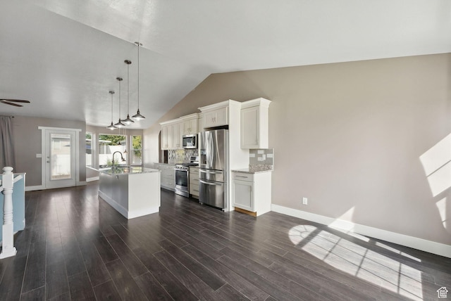 kitchen featuring dark wood-style flooring, white cabinets, a kitchen island with sink, and appliances with stainless steel finishes