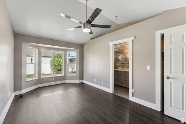 unfurnished bedroom featuring dark wood finished floors, vaulted ceiling, baseboards, and visible vents