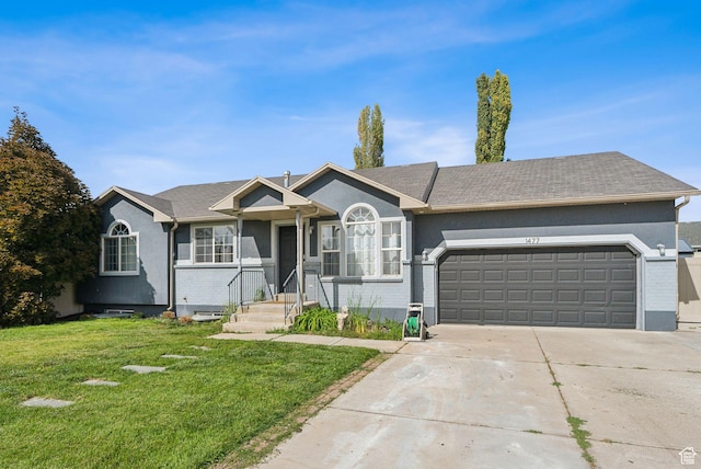 ranch-style home featuring concrete driveway, an attached garage, stucco siding, and a front yard