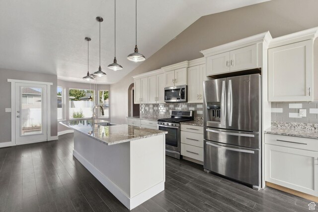 kitchen featuring a sink, stainless steel appliances, a kitchen island with sink, vaulted ceiling, and white cabinets