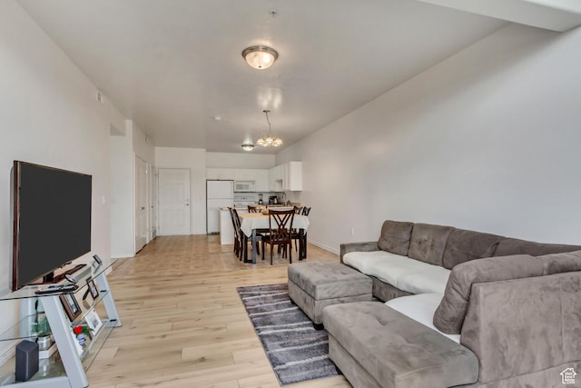 3478 S Cozy River Pl Unit 402, West Valley City, UT 84119 - living area featuring baseboards, a chandelier, and light wood-type flooring