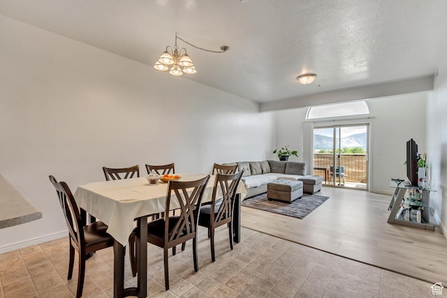 3478 S Cozy River Pl Unit 402, West Valley City, UT 84119 - dining space featuring baseboards, light wood-style floors, and an inviting chandelier