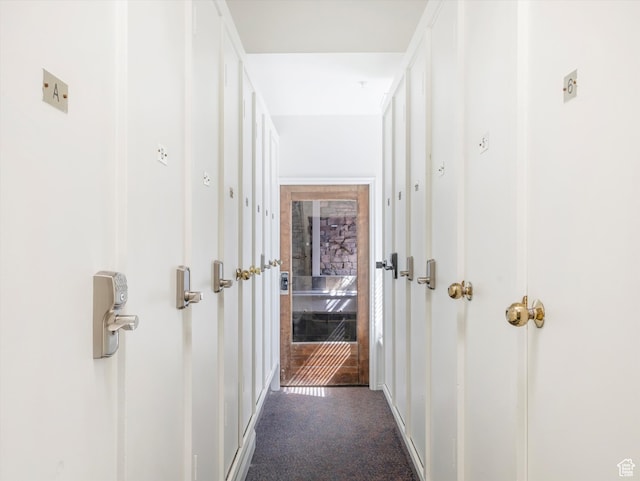 hallway with dark colored carpet