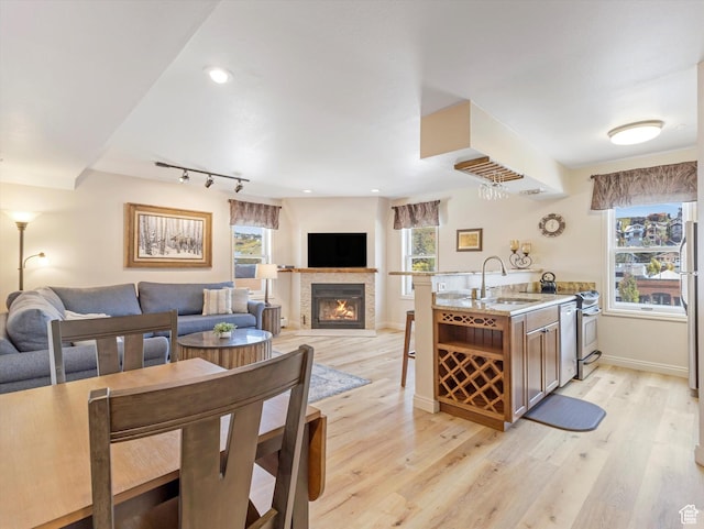 424 Park Ave Unit D, Park City, UT 84060 - kitchen with a sink, open floor plan, light wood-style flooring, a lit fireplace, and light countertops